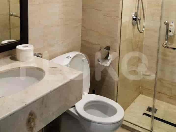 A modern bathroom with a toilet, sink and a shower.