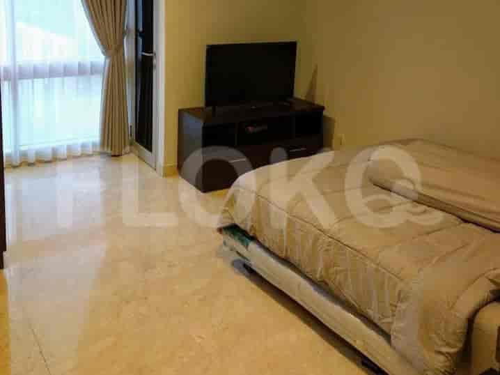 A bedroom with a bed and a TV stand.