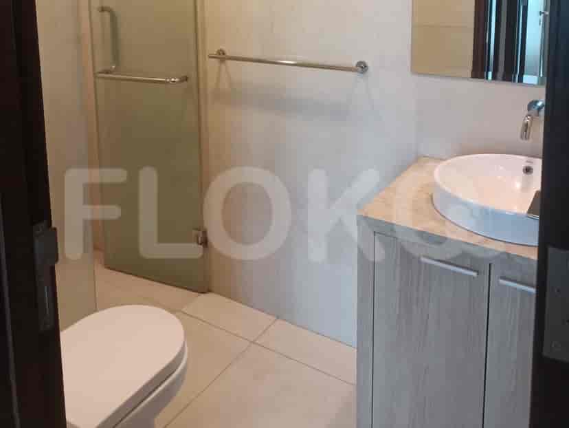 Kamar mandi modern dengan pancuran kaca dan meja rias.