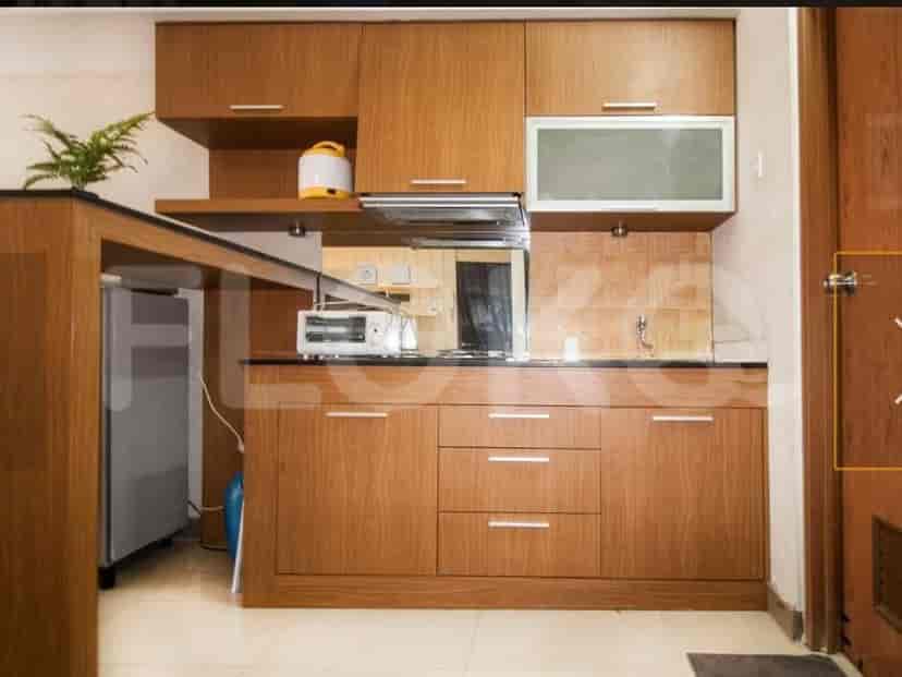 A kitchen with wooden cabinets and a bar area.