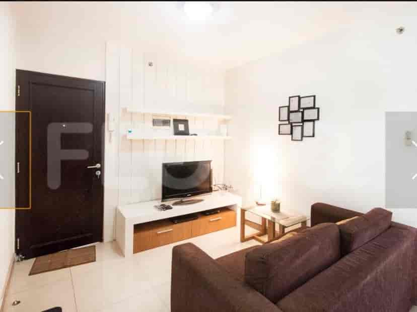 A living room featuring a TV cabinet, shelves, and a sofa.