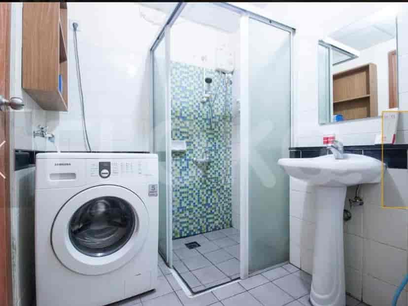 A bathroom with a shower and a washing machine.