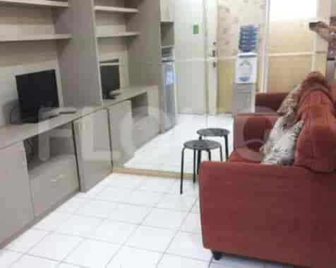 A living room featuring a red sofa, white tiled floor, and built-in storage.
