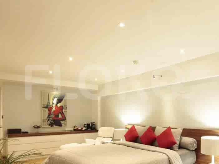 Kamar tidur modern dengan tempat tidur besar, seni, dan pencahayaan tersembunyi.