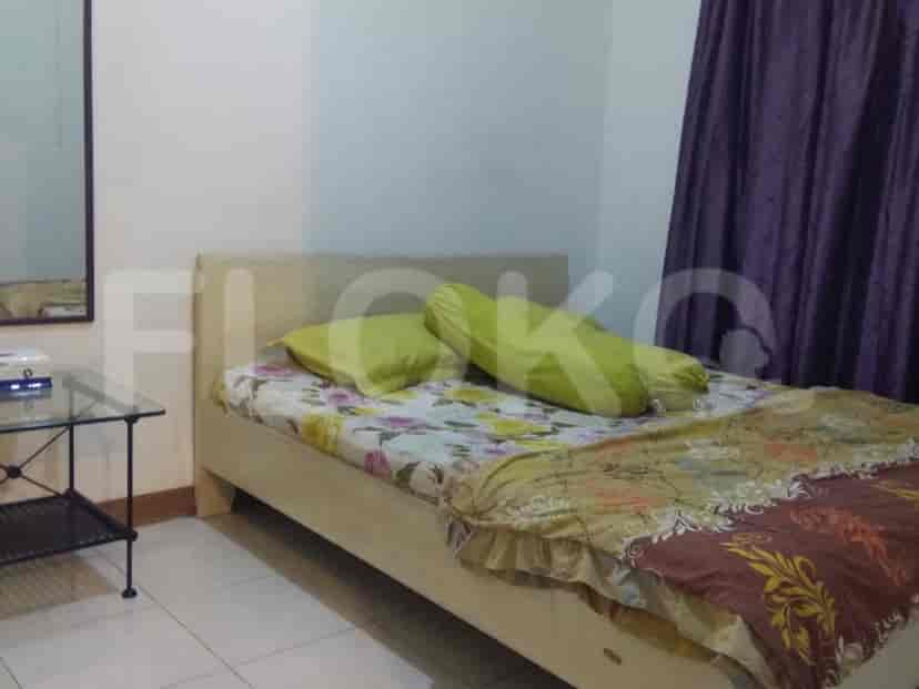 Bedroom with a bed, mirror, and curtains.
