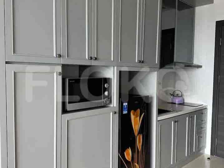 A close-up of the built-in kitchenette featuring a microwave, refrigerator, and countertop.