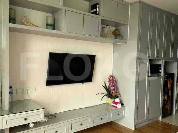 Modern entertainment area featuring a wall-mounted TV, built-in storage, and a small countertop with drawers.