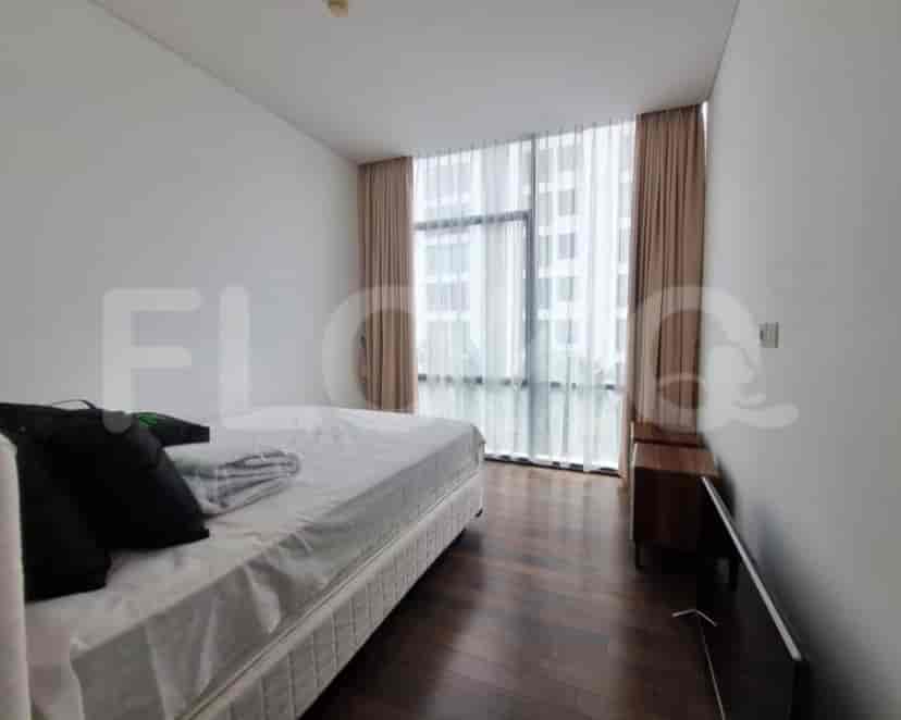 A minimalist bedroom with a bed, wooden side table, and large windows.