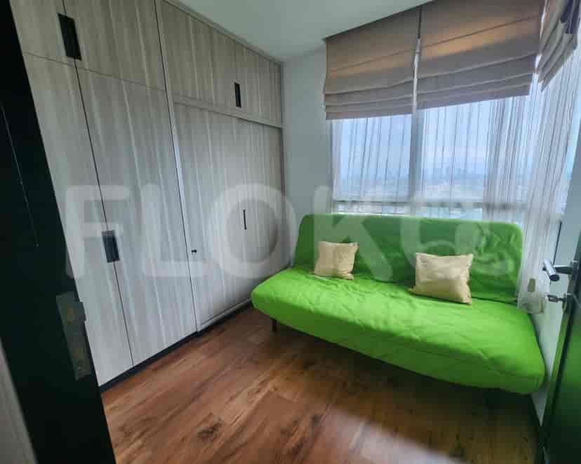 Cozy bedroom with a green sofa bed and built-in wardrobe.