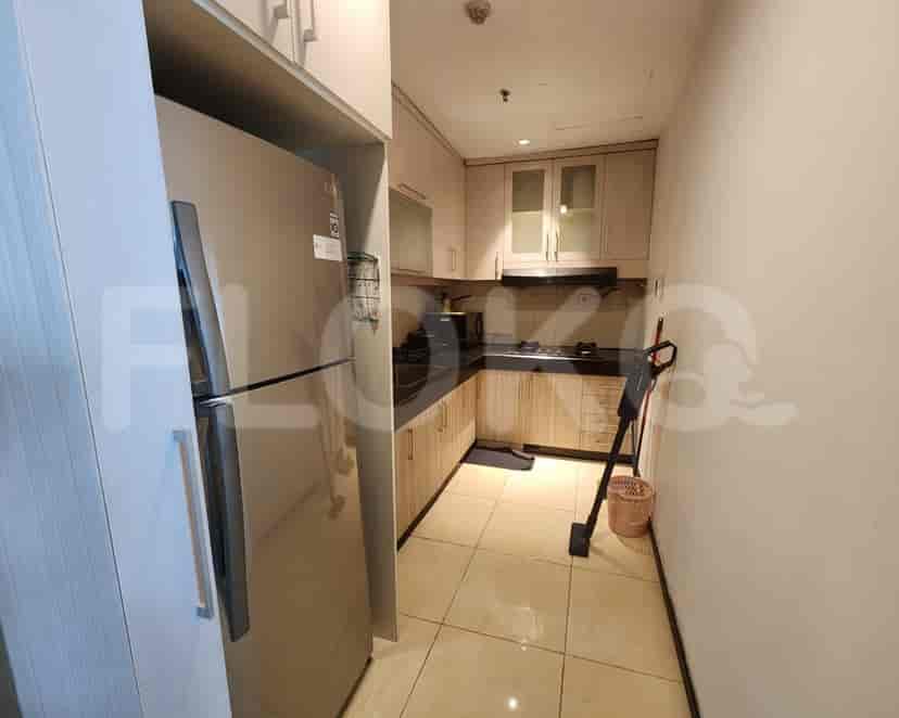Compact kitchen with light wood cabinets, a refrigerator, and gas stove.