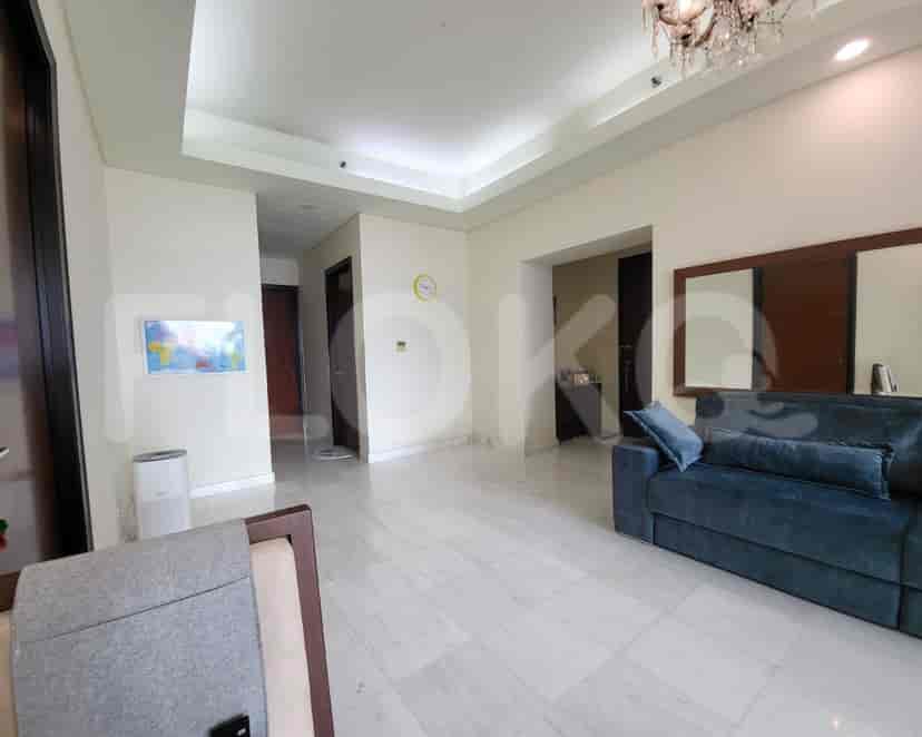 Bright living room with marble flooring, a blue sofa, and access to other rooms.
