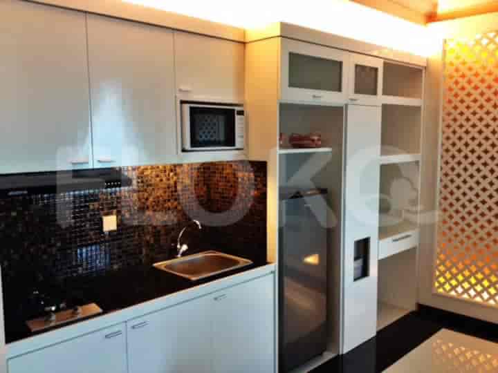 Dapur modern dengan lemari putih, meja hitam, dan peralatan stainless steel.