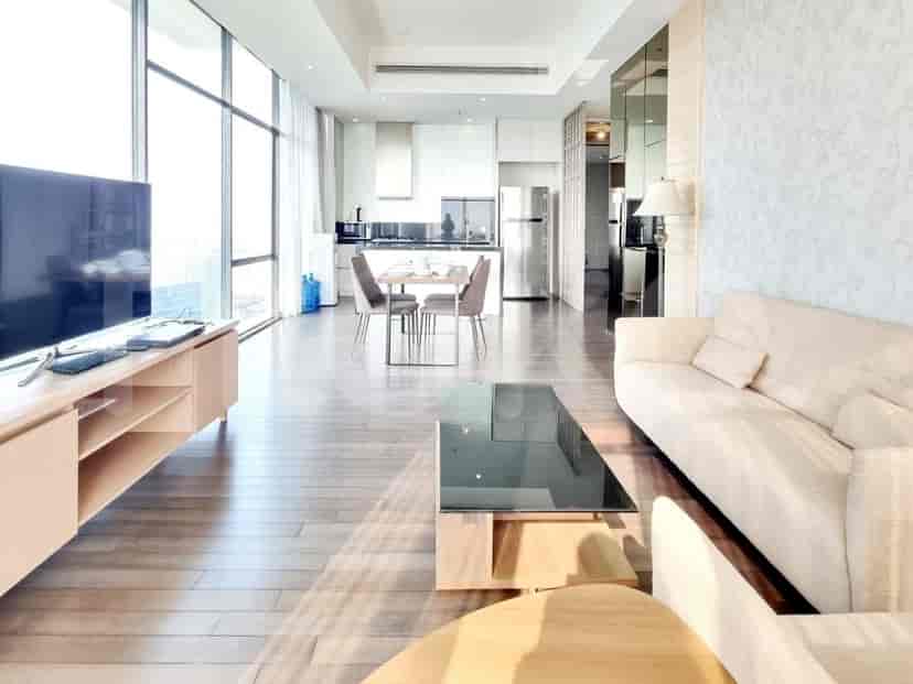 Modern living room with wooden floors, a large window, and integrated kitchen.