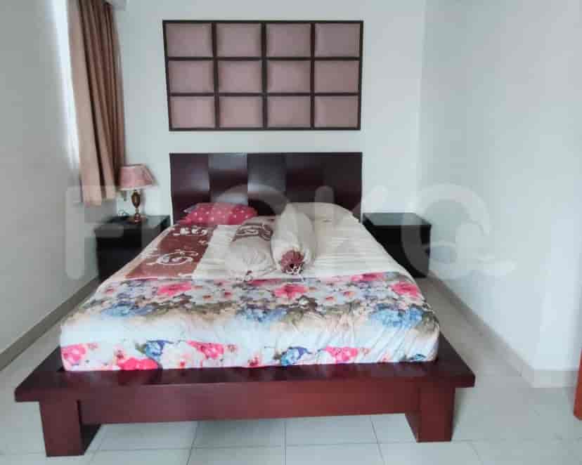 A bedroom with a bed, nightstands, and wall decor.