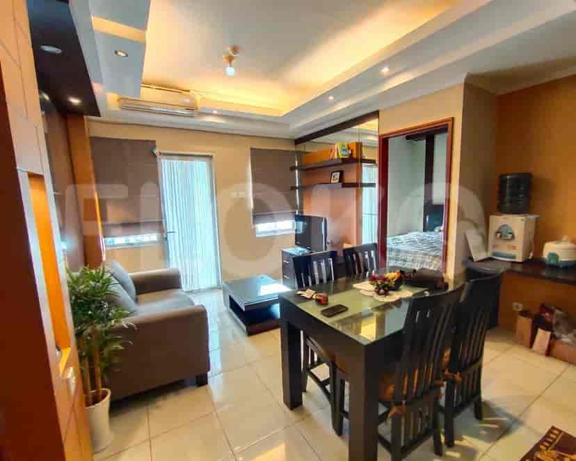 Living room with dining table set, sofa, and view of kitchen.
