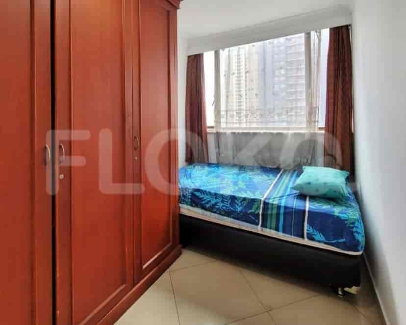 A small bedroom with a single bed and a wardrobe.
