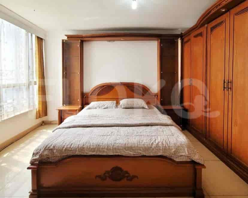 A master bedroom with a large wooden bed, a wardrobe, and a window.