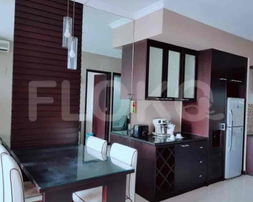 Dapur dan ruang makan dengan meja makan, lemari, dan lemari es.