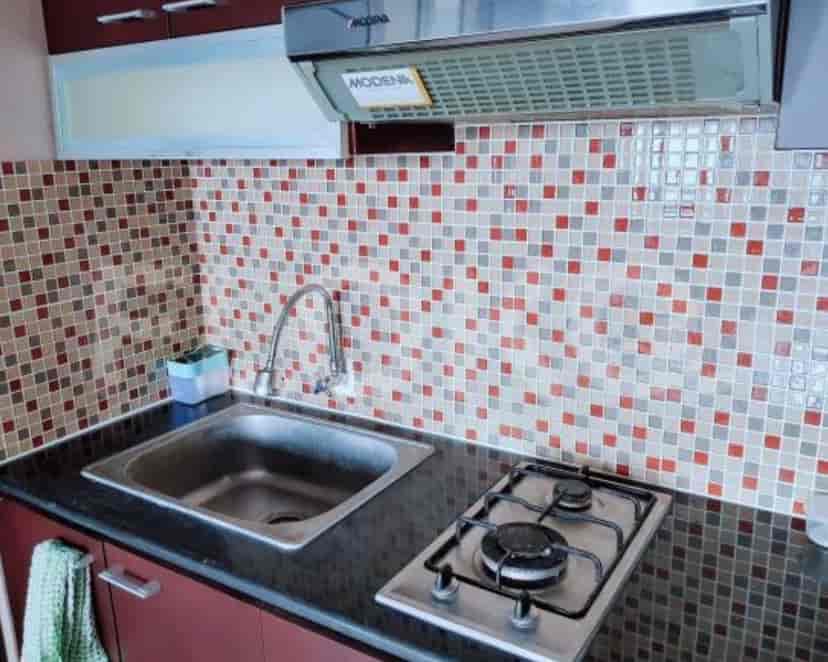 Dapur yang menampilkan kompor gas, wastafel, dan backsplash ubin.
