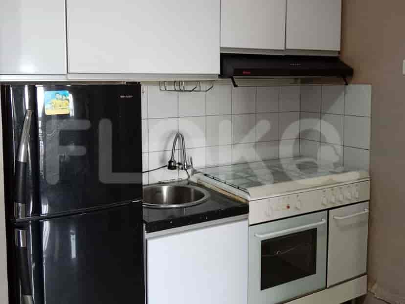 A small kitchen with black refrigerator, stove, and sink.