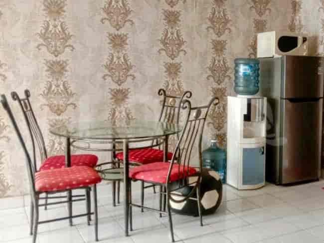 Dining area with a table and chairs near a refrigerator.