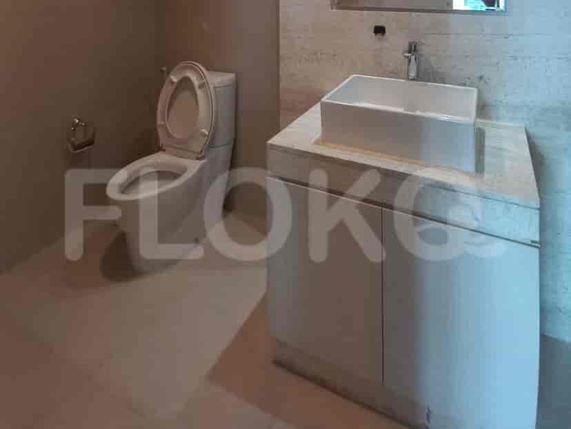 A modern bathroom with a toilet, sink and marble floor.