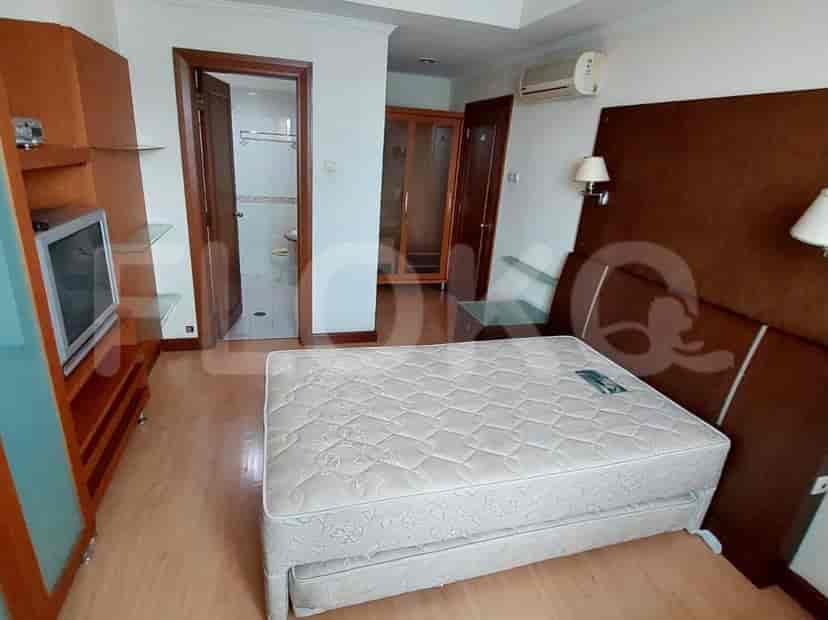 A bedroom with a bed, a wardrobe, and a bathroom entrance.