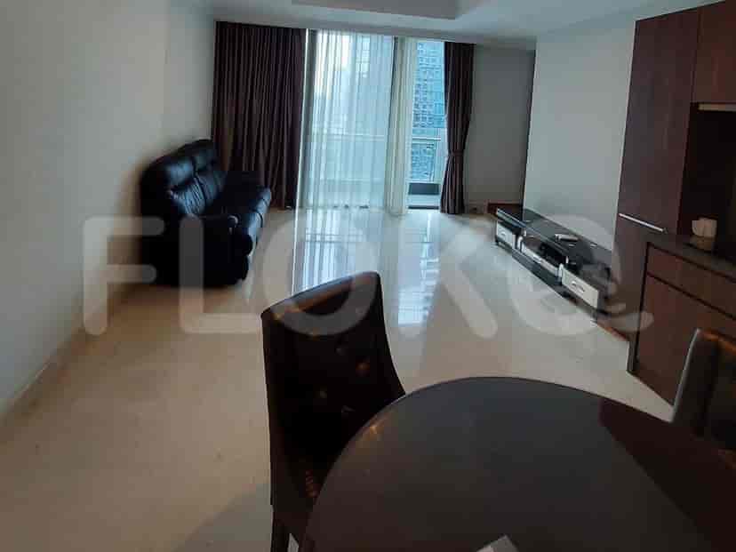 Living room featuring a black leather sofa, a round dining table, and a view of the city.