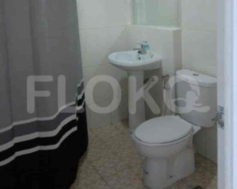 A small bathroom with a pedestal sink, toilet, and shower curtain.