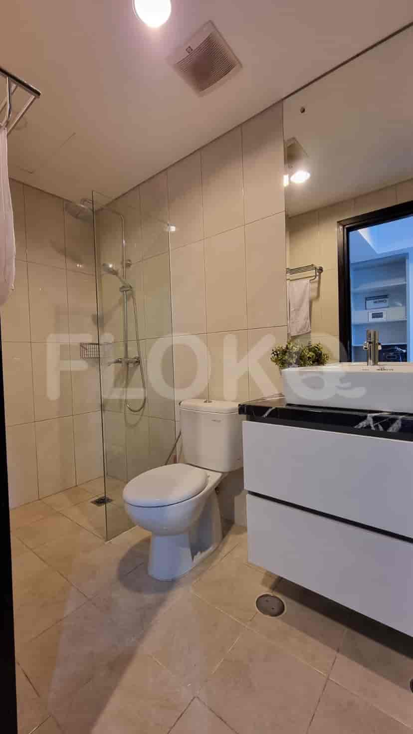 Modern bathroom with a glass-enclosed shower, vanity, and toilet.
