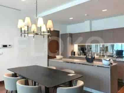 Area dapur dan ruang makan gabungan dengan pulau besar, meja makan, dan lampu gantung modern.