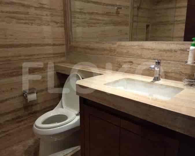 Bathroom with a toilet, sink, and neutral color palette.