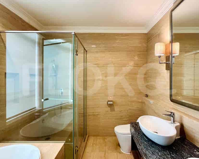 A modern bathroom featuring a glass-enclosed shower, bathtub, and marble finishes.