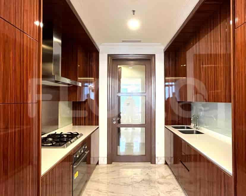 A modern kitchen with wooden cabinets, stainless steel appliances, and marble flooring.