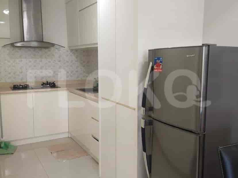 A modern kitchen with white cabinets, a gas stove, and a refrigerator.