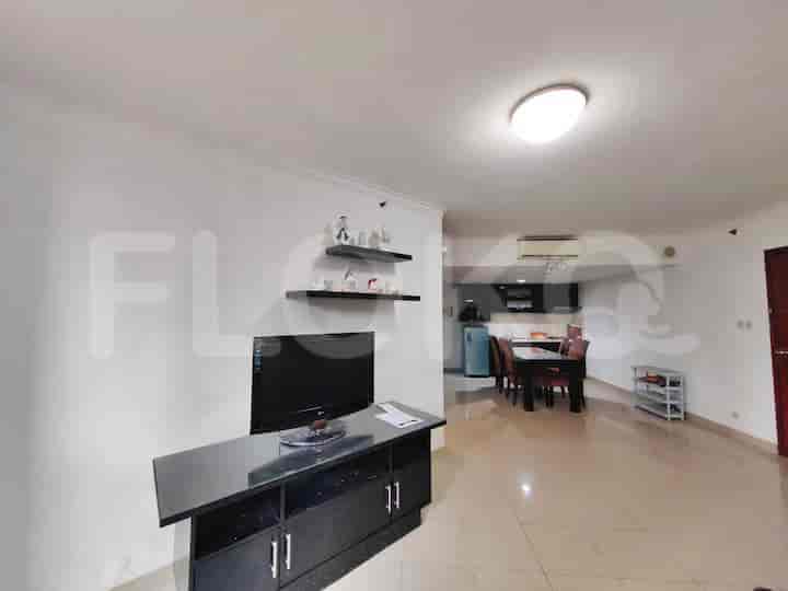 Open-plan living and kitchen area with a TV and dining table.