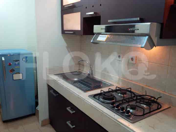 Dapur kecil dengan peralatan penting, termasuk lemari es dan kompor gas.