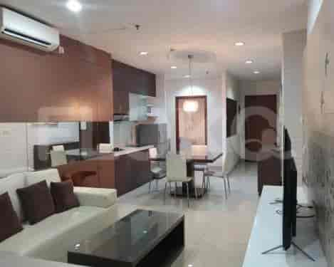 Modern living space with a kitchen, dining area, and living room, featuring a cream sofa, dining table, and built-in kitchen.