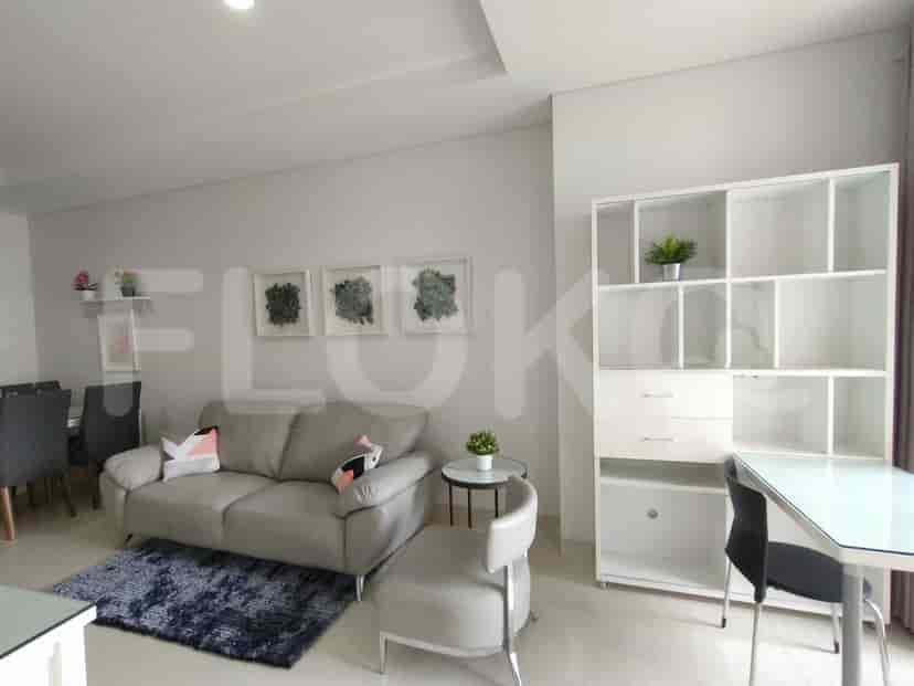 Living room with sofa, shelving unit, and dining area.