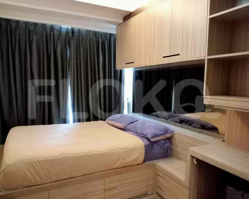 A compact bedroom with a bed, storage, and a built-in wardrobe.