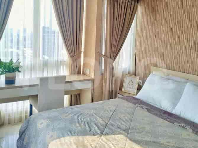 Bedroom with a bed, desk and large windows.