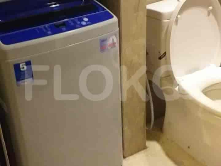 Bathroom with a washing machine and toilet.