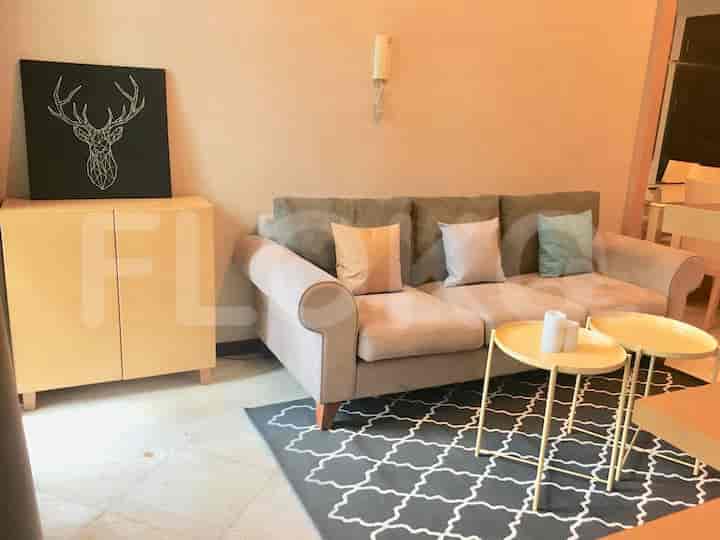Living room with beige sofa, coffee tables, cabinet, and artwork.