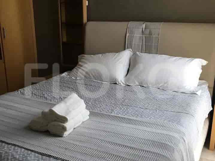 Bedroom with double bed, towels, and a wardrobe.