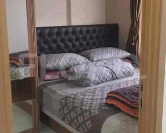 A bedroom with a bed and a mirror.