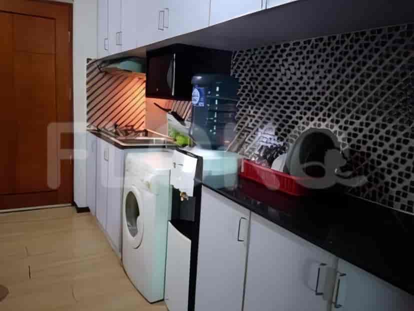 Dapur modern dengan lemari putih, meja hitam, dan mesin cuci.