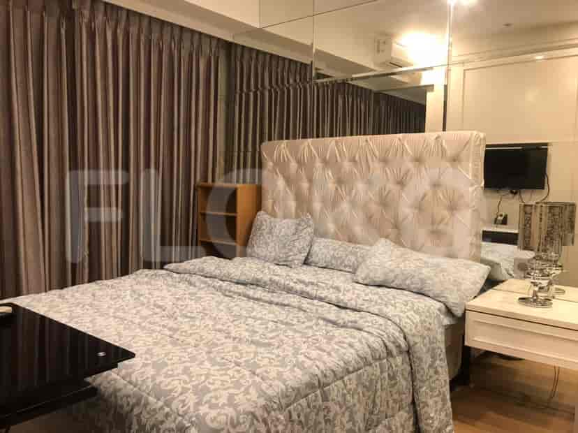 Kamar tidur yang menampilkan tempat tidur besar dengan dinding cermin.