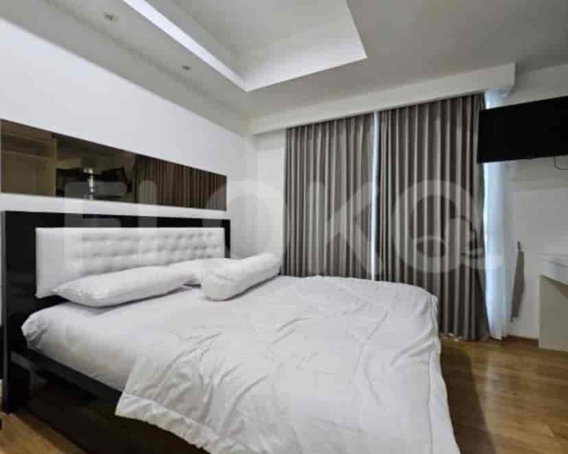 A bedroom with a king-size bed, a mirror, and curtains.