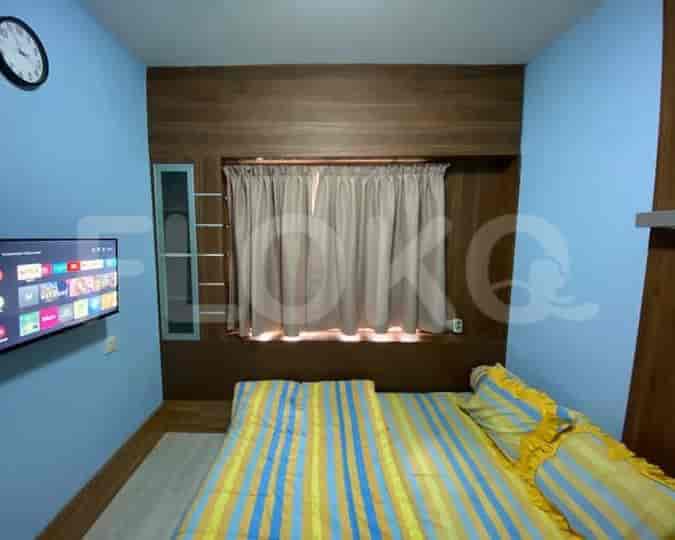 Cozy bedroom with a bed, TV, and window.