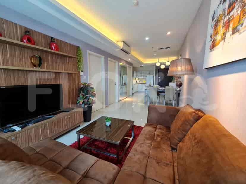 Living room with brown sofa, wooden TV stand, and dining area.